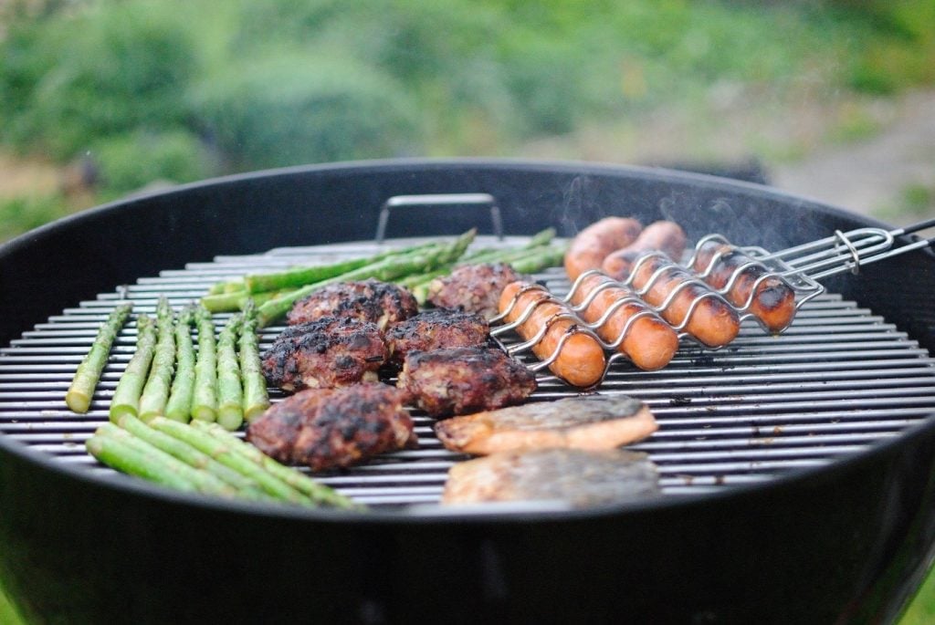 Round BBQ with sizzling asparagus, burgers and sausages